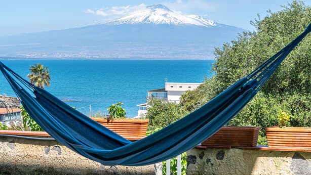 A hammock overlooking a coastal view with a mountain in the background. - Apartment in Villa 'Il Limone, La Salvia e il Rosmarino' with Sea View, Private Terrace and Wi-Fi (Augusta)