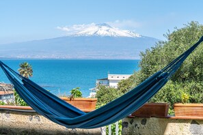 A hammock overlooking a coastal view with a mountain in the background. - Apartment in Villa 'Il Limone, La Salvia e il Rosmarino' with Sea View, Private Terrace and Wi-Fi (Augusta)