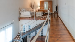 A staircase with rope railings, a wooden floor, and a bed with a patterned cover. - Apartment in Villa 'Il Limone, La Salvia e il Rosmarino' with Sea View, Private Terrace and Wi-Fi (Augusta)