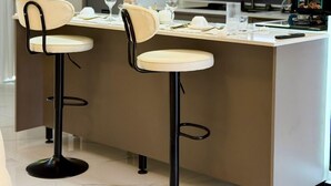 A modern kitchen with a central island, two bar stools, and a built-in coffee machine. - Simba Heights Kyanja (Kampala)