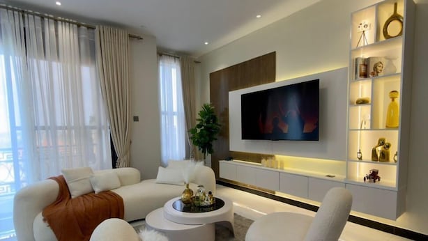 A modern living room with a sofa set, a coffee table, and a TV mounted on the wall. - Simba Heights Kyanja (Kampala)