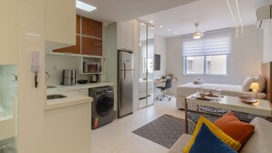 A modern kitchen with a washing machine, a refrigerator, and a dining area with a table and chairs. - 5 Minutes From Copacabana Beach B703 (Rio de Janeiro)