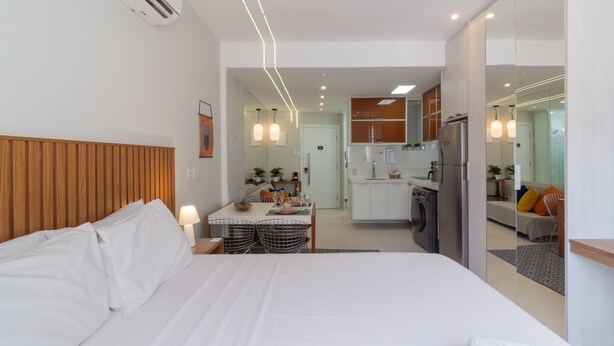 A modern hotel room with a large bed, a dining area, and a kitchenette. - 5 Minutes From Copacabana Beach B703 (Rio de Janeiro)