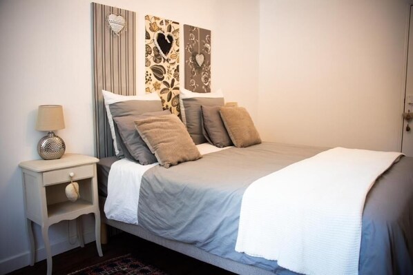 Un dormitorio con cama, mesita de noche y decoración en la pared.
