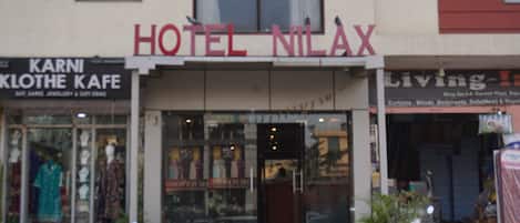 A hotel named "HOTEL NILAX" with a storefront featuring mannequins in traditional attire.