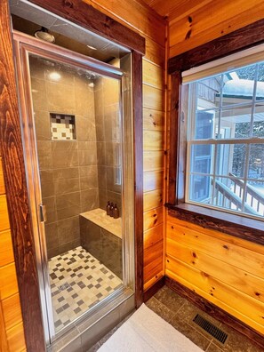 A wooden cabin bathroom with a shower, a window, and a checkered floor. - Private, Comfy Cabin in Rangeley/Trails, Lakes, Fire Pit/Sleeps 8/Starry Sky (Rangeley)