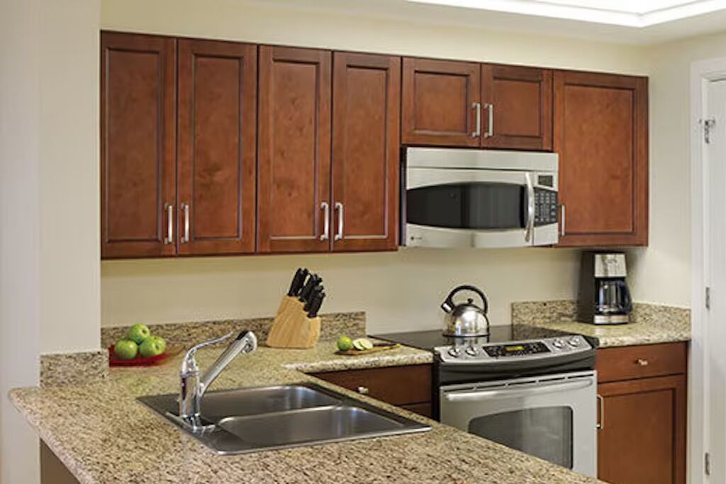 A kitchen with granite countertops, stainless steel appliances, and wooden cabinets.