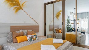 Una camera da letto moderna con un letto grande, una testiera in legno e uno specchio.