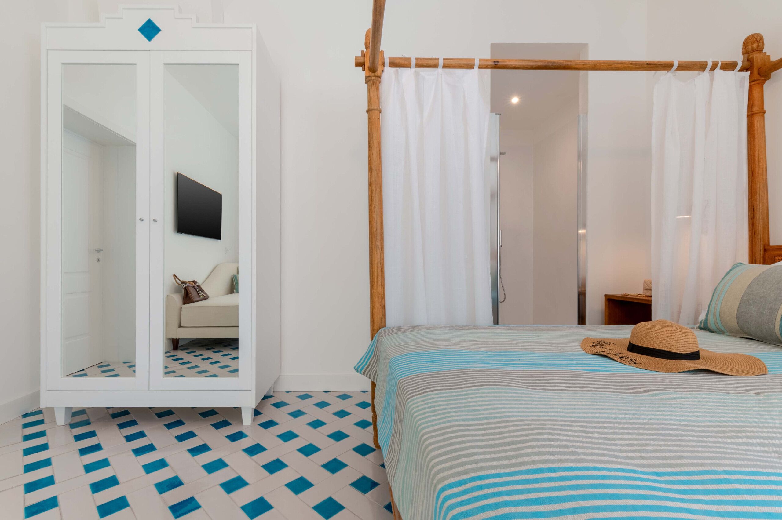 A bedroom with a bed, a wardrobe, a mirror, and a canopy bed.
