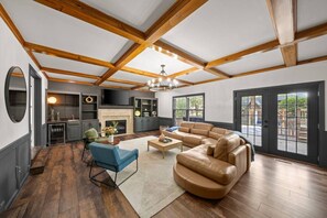 Ein geräumiges Wohnzimmer mit einer großen L-förmigen Couch, einem Kamin und einem Essbereich mit Tisch und Stühlen.