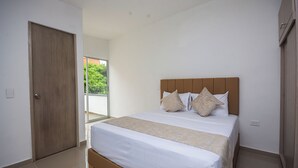 Una camera da letto con un letto grande, una porta in legno e vista su del verde all'esterno.