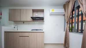 Una cucina moderna con mobili in legno chiaro, un lavello in acciaio inossidabile e un piano cottura a gas.
