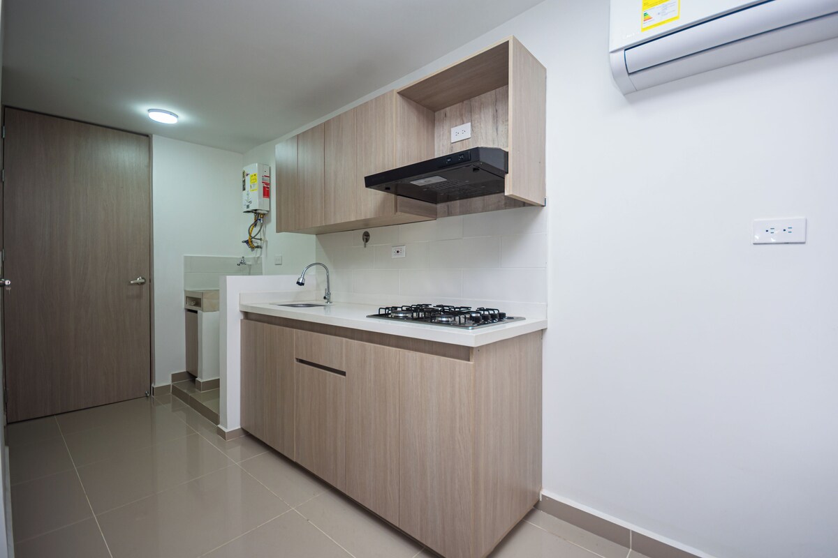 A modern kitchen with wooden cabinets, a gas stove, and a built-in oven.