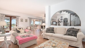 Ein geräumiges Wohnzimmer mit zwei Sofas, einem Couchtisch und einem Essbereich.