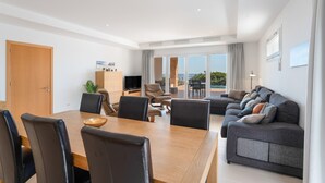 Een moderne woonkamer met een eethoek, een bank en een televisie.