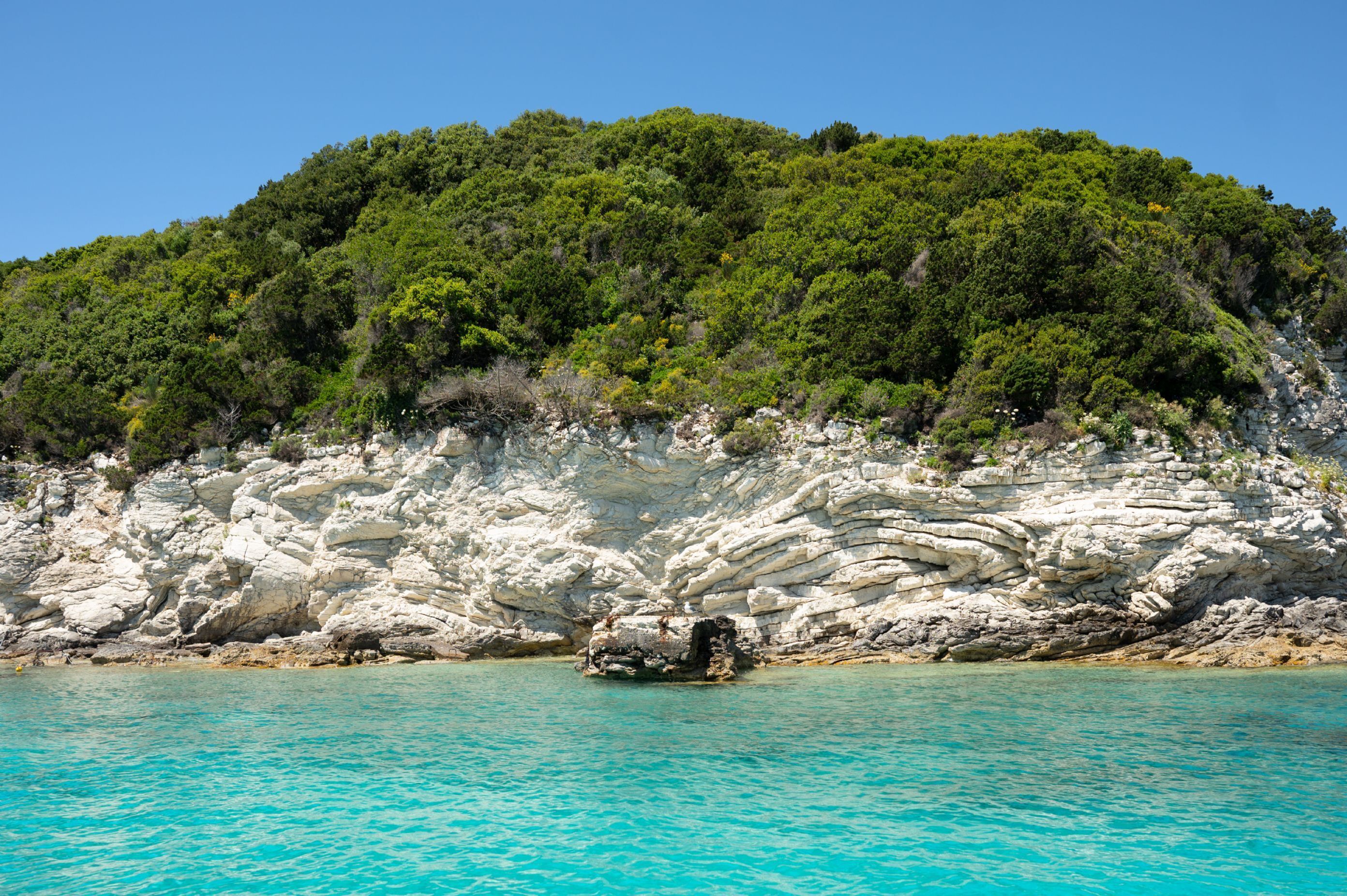 Un paysage côtier caractérisé par de hautes falaises blanches et des eaux turquoise.