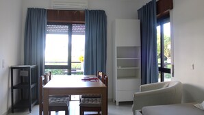 Ein Essbereich mit Tisch, Stühlen, einer Couch und einem Bücherregal.