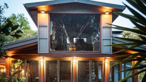 A modern two-story house with large glass windows and a well-lit interior. - Inspiring Loft in the forest. Armonía Natura House (Camargo)