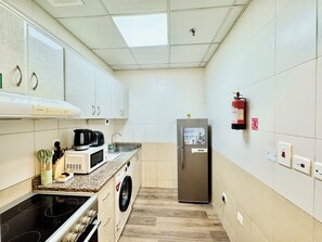 Business Apartment, City View | Private kitchen | Full-sized fridge, microwave, oven, stovetop - Cosmos Living Work-Friendly Metro Access (Dubai)