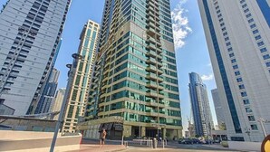 Un edificio de gran altura con varios pisos, rodeado de otros edificios altos.