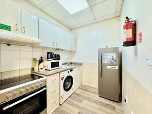 Apartamento empresarial, vista para a cidade | Cozinha privada | Geladeira grande, micro-ondas, fogão, cooktop