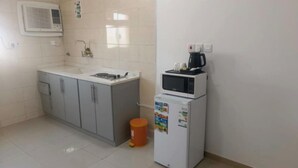 Una pequeña kitchenette equipada con pileta, placares, microondas y refrigerador.