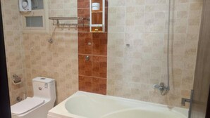 Un baño con bañera, inodoro y ducha.