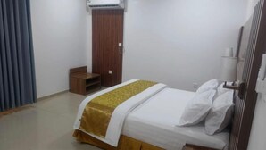 Una habitación pequeña y limpia con cama, un armario de madera y una mesita.