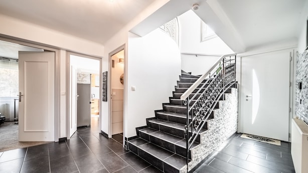 A modern interior with a staircase, dark flooring, and white walls. - Villa "L'Oranaise" – 190 m², Mountain View, Private Balconies, Terraces & Garden (Cluses)