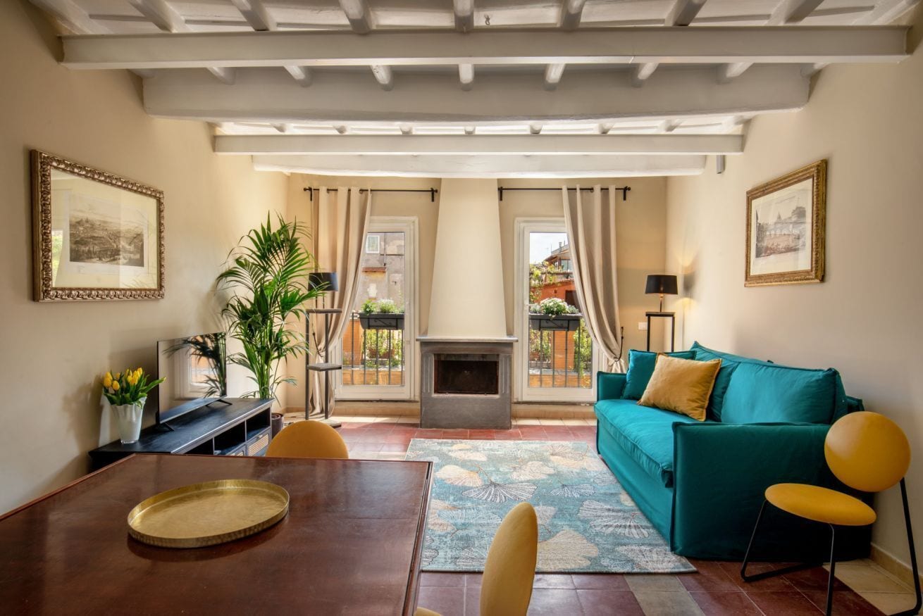 Ein Wohnzimmer mit einer Couch, einem Esstisch und einem Kamin.