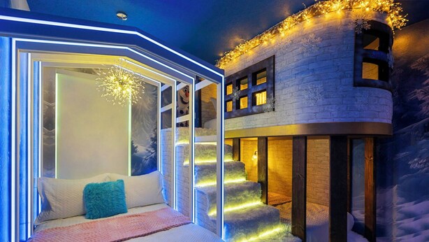 Un dormitorio acogedor con cama, ventana y una escalera que sube a un segundo piso.