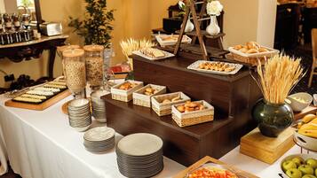 A buffet setup with various food items and serving ware.