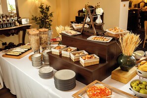 A buffet setup with various food items and serving ware. - Classic Inn Hotel (Brasov)