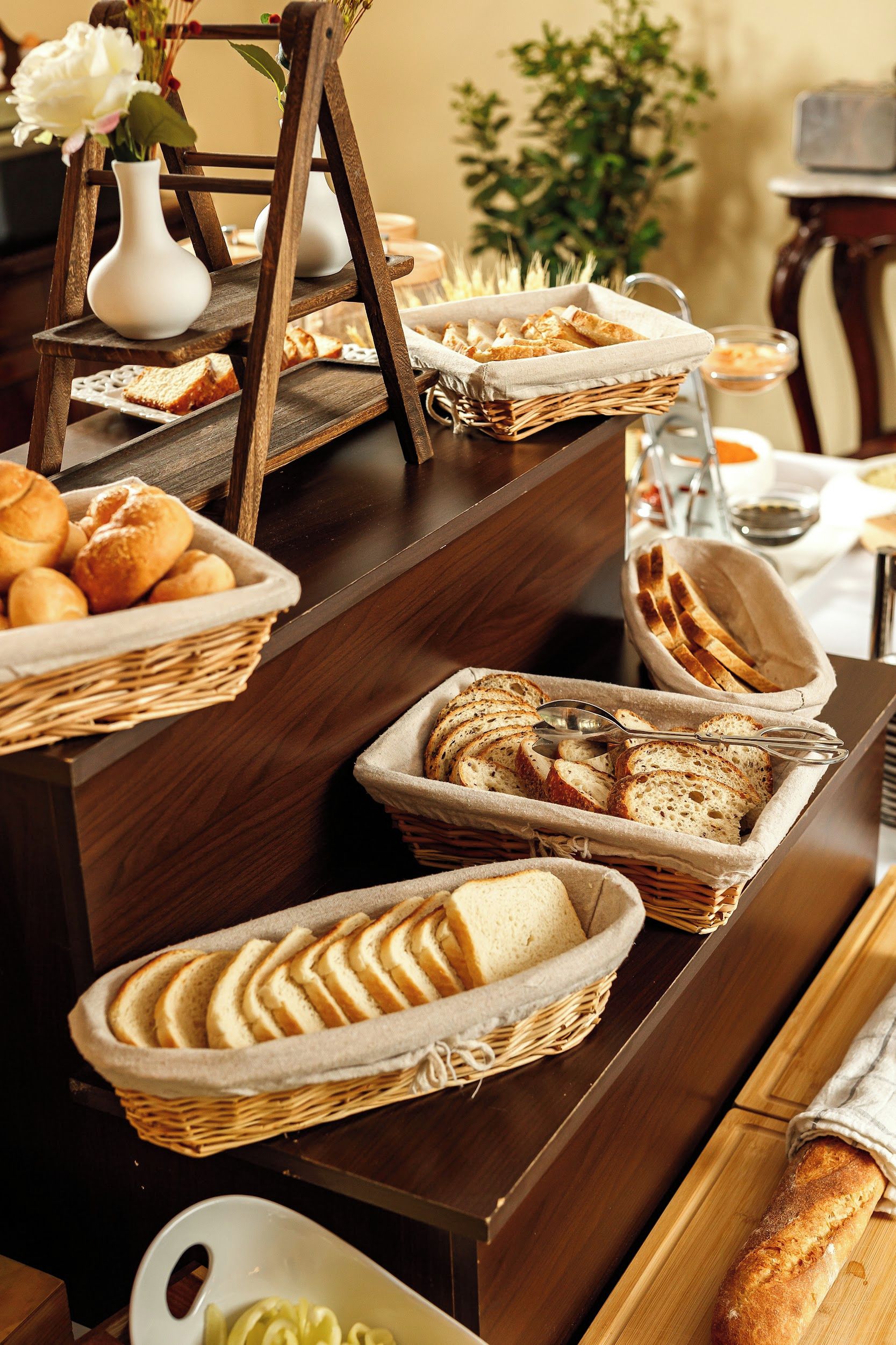 Una mesa de buffet con panes y pasteles varios.