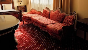 Ein Zimmer mit einem großen Bett, einem Schlafsofa, einem kleinen Tisch und einem Schreibtisch.