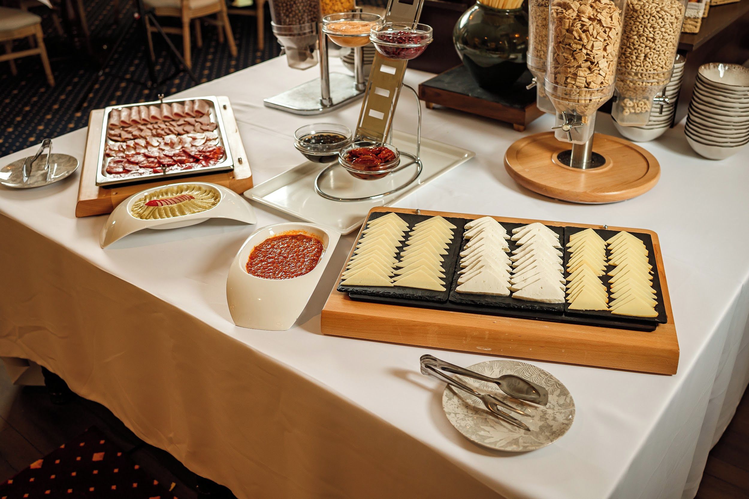 Un tavolo da buffet con diversi cibi e utensili per servire.