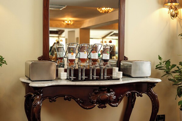 A bar area with a mirror reflecting the interior, a coffee machine, and a toaster on a marble countertop. - Classic Inn Hotel (Brasov)