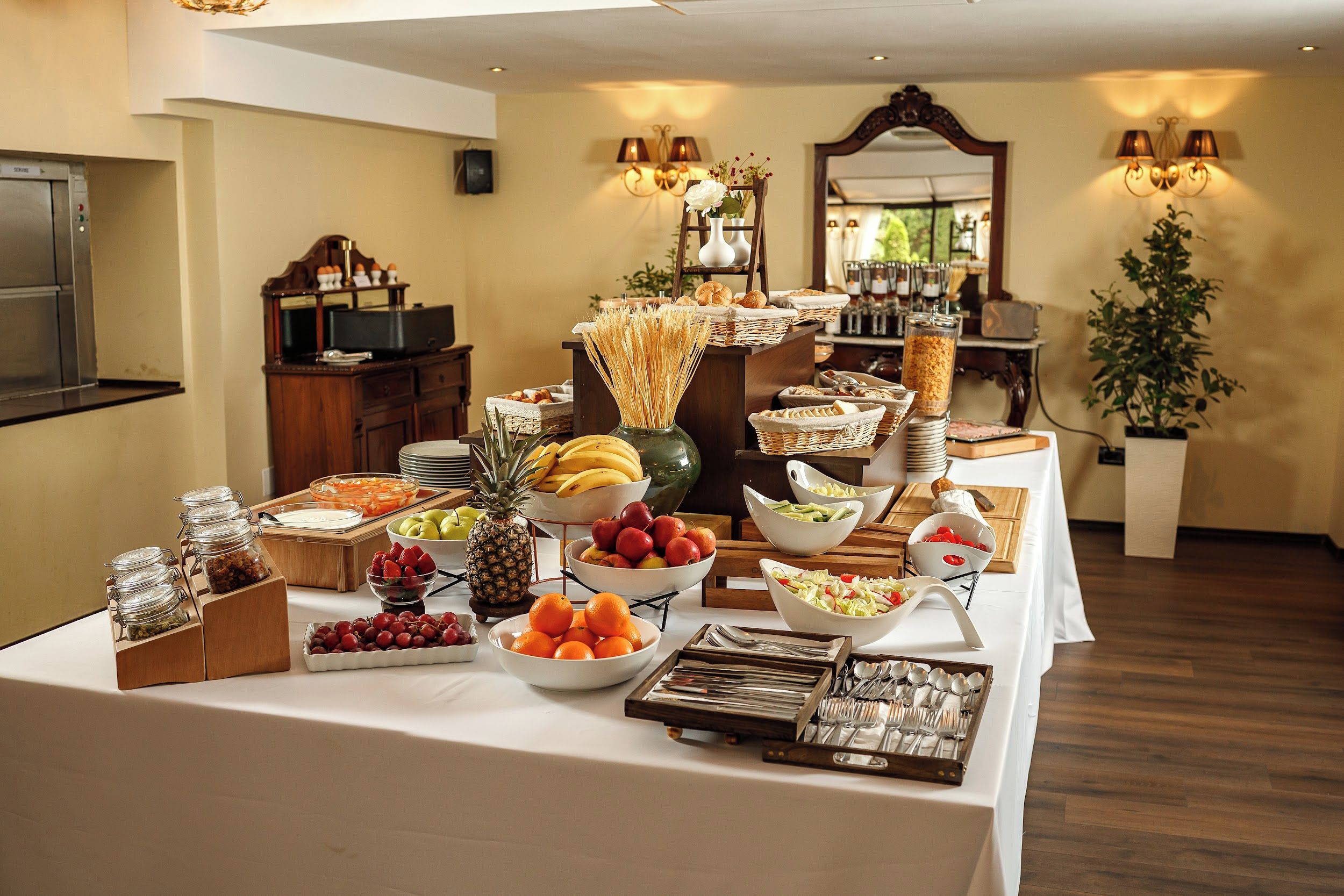 A buffet table with various food items and utensils.