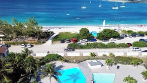 Et resort med to store swimmingpools, en strand og havudsigt.