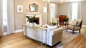 Una sala de estar con chimenea, un sofá, una silla y una mesa de centro.