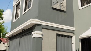 A building with a sign reading "ELINDE DE LA MODERNA" and two large grey garage doors. - El Inn de la Moderna (San Pedro Sula)