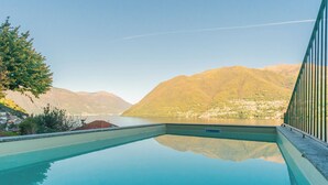 Une piscine offrant une vue dégagée sur les montagnes et une ville en arrière-plan.