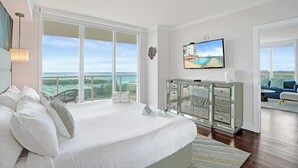 Ein Schlafzimmer mit einem großen Bett, einem Fernseher und Meerblick.