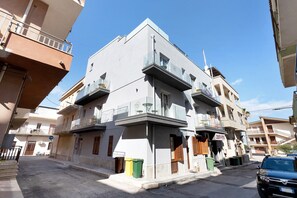 A multi-story building with balconies, a visible storefront, and a parked car. - Room 'Camera 2 - P1' with Balcony, Wi-Fi and Air Conditioning (Balestrate)