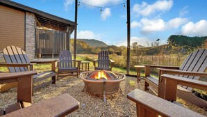 A patio with Adirondack chairs, a fire pit, and a view of a mountain landscape. - Fab New 2 Level Build I Fire Pit I Private Hot Tub I Game Room (Sevierville)