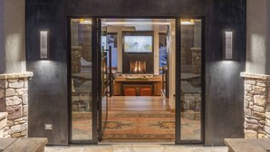 Ein modernes Interieur mit Kamin, Steinwänden und einer Glastür.