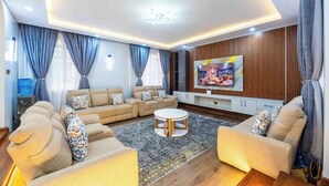 Una sala de estar moderna con un conjunto de sofá, una mesa de centro y un televisor montado en la pared.