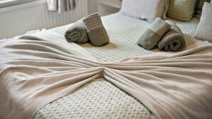 A neatly made bed with rolled towels and a textured blanket. - Heartwarming Windsor Cottage with Free Parking (Berkshire)