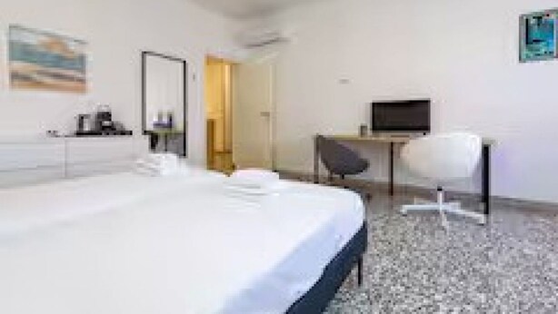 Une chambre d’hôtel équipée d’un lit, d’un bureau, d’une chaise et d’un téléviseur.