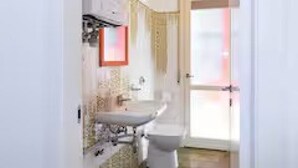 Une salle de bain avec un lavabo, un miroir et des toilettes.